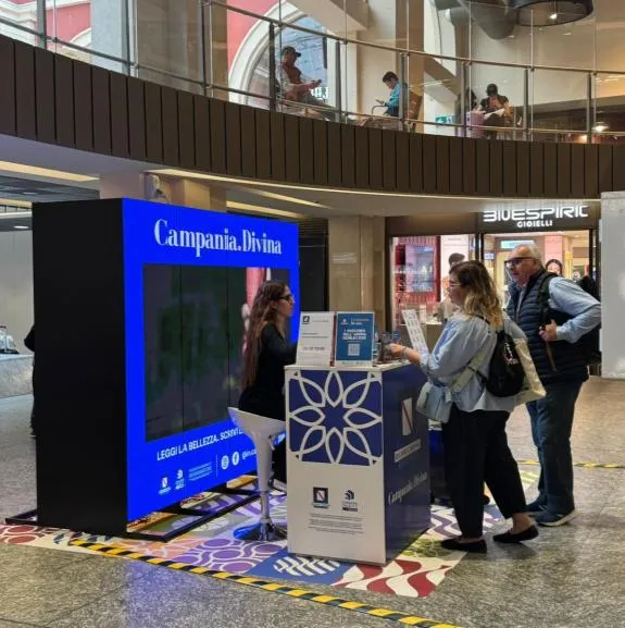 Postazione Campania.Divina con schermo e desk informativo in stazione
